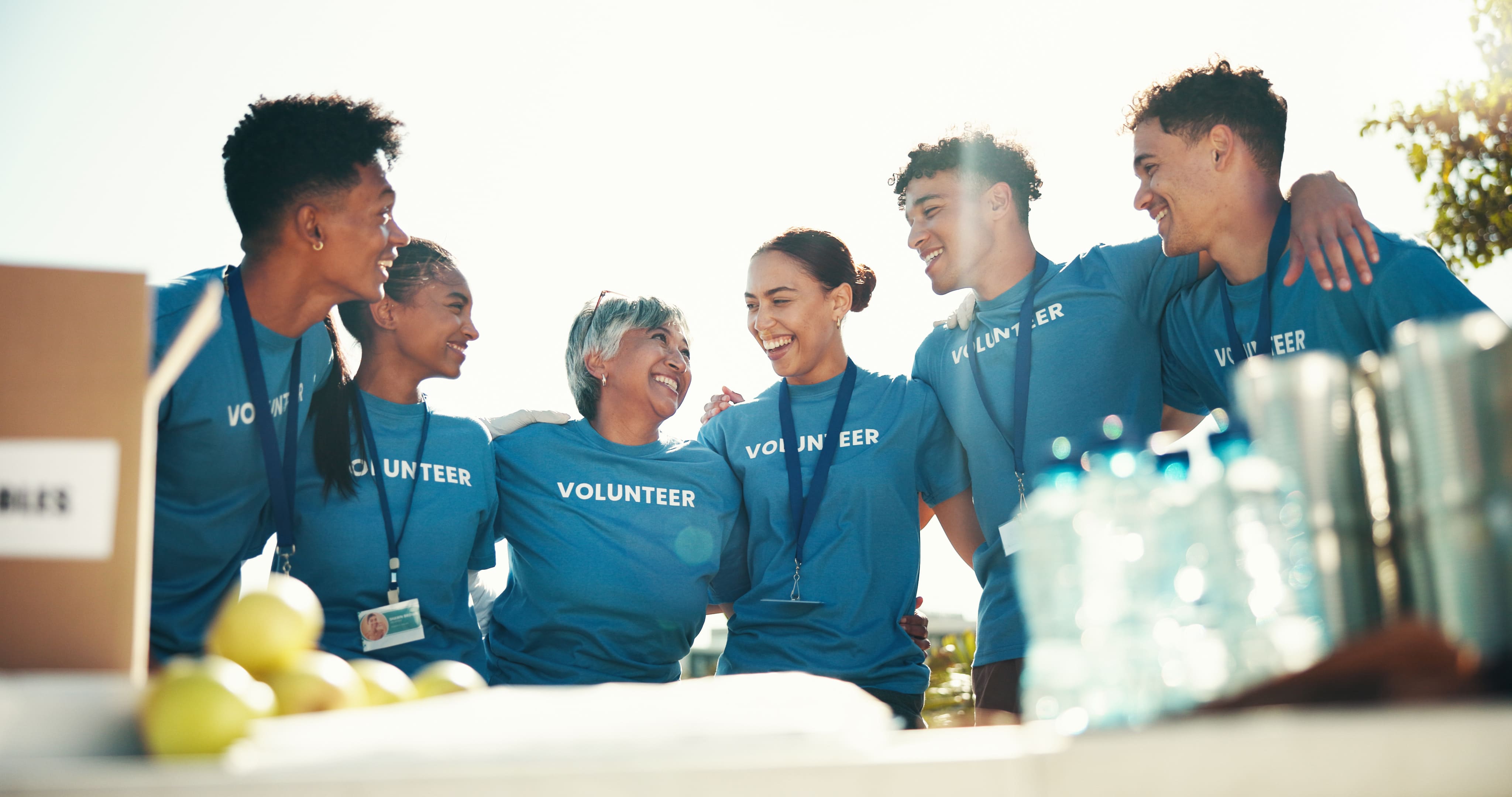 unity-hug-and-group-of-volunteers-smile-and-prou-2025-04-06-10-34-38-utc